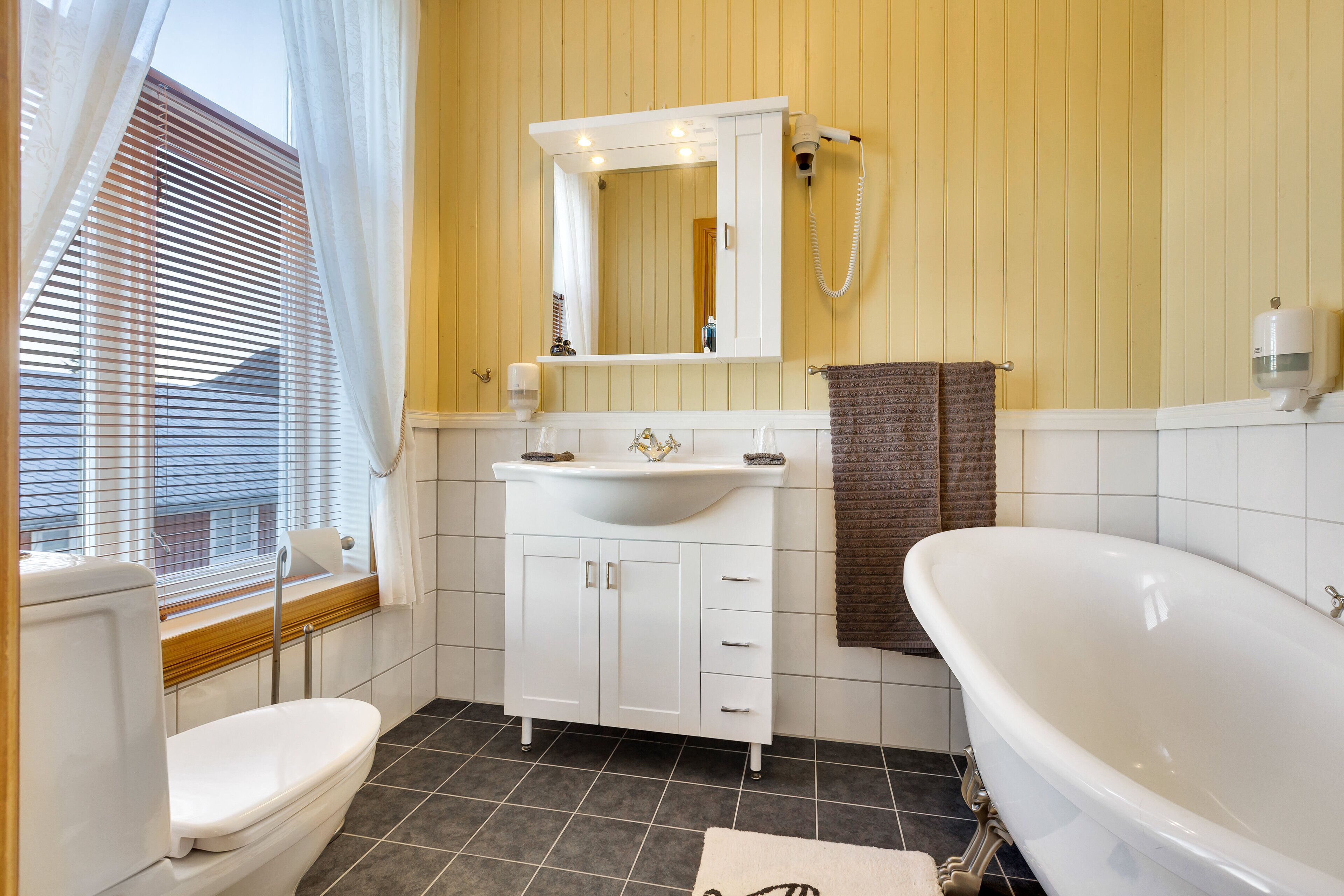 Un baño con inodoro, lavamanos y bañera.