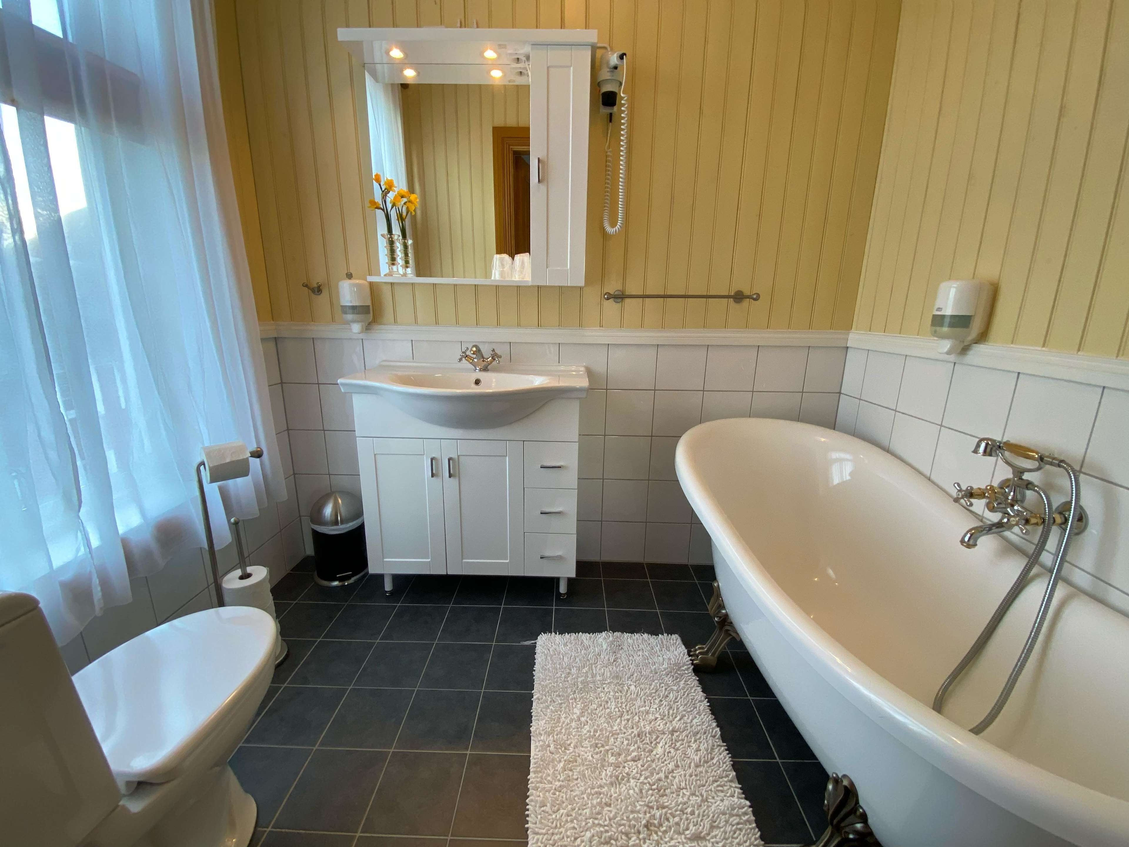 A bathroom with a toilet, sink, and bathtub.
