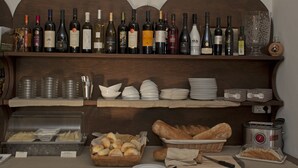 A buffet setup with various food items and a selection of wine bottles. - Nascar Hotel (Baunei)