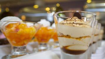 A dessert tray with various layered desserts in clear glasses.