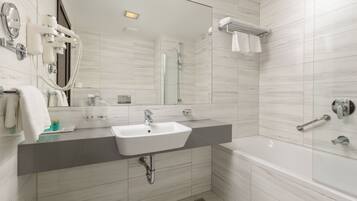 Un bagno moderno con uno specchio grande, un lavandino, una doccia e una vasca da bagno.