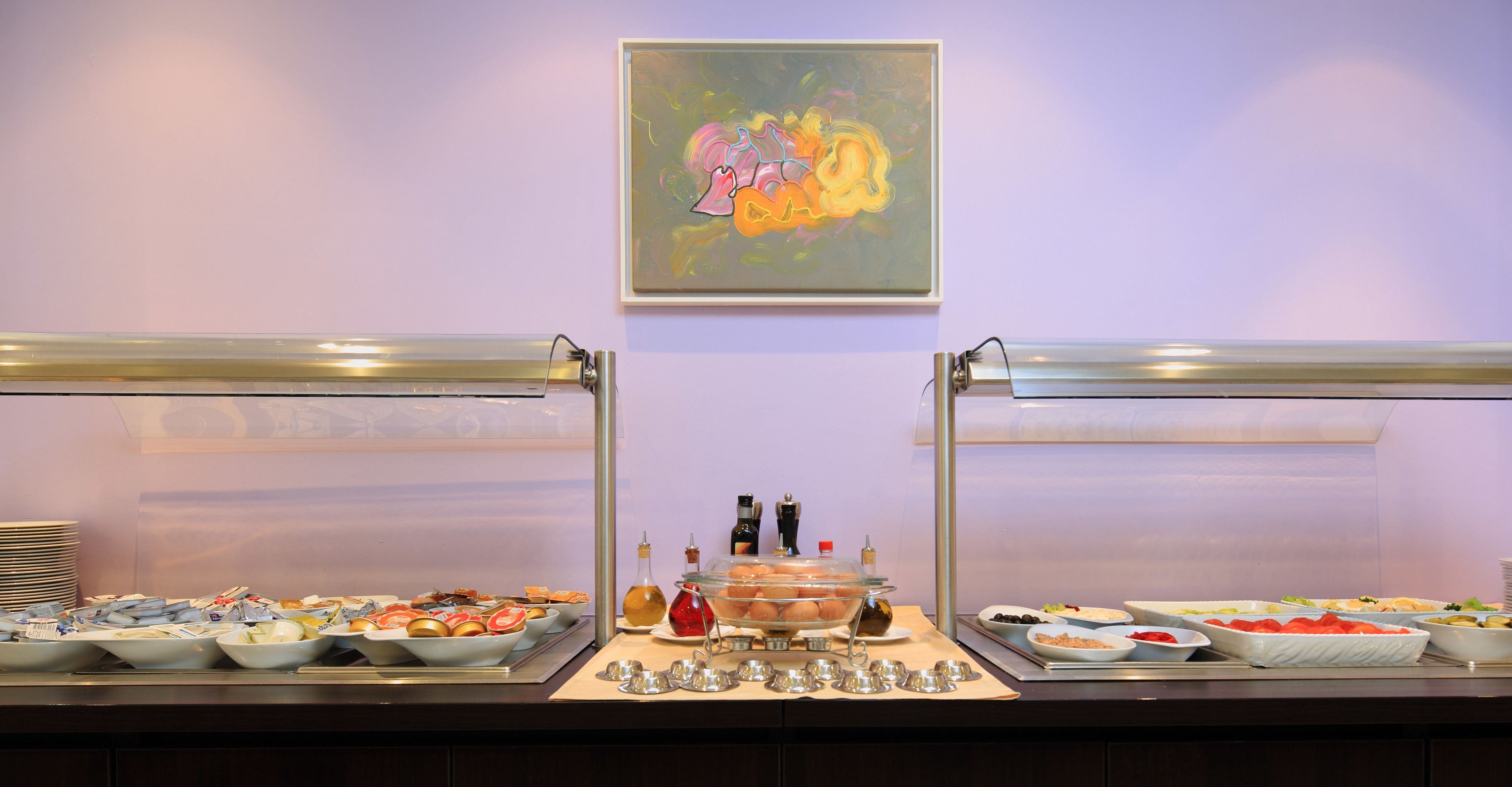 A buffet setup with various food items and condiments.