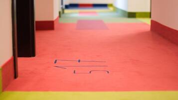 A corridor with a red carpet and a yellow baseboard.
