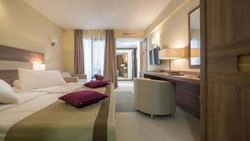 Una habitación de hotel con cama, escritorio, silla y espejo.