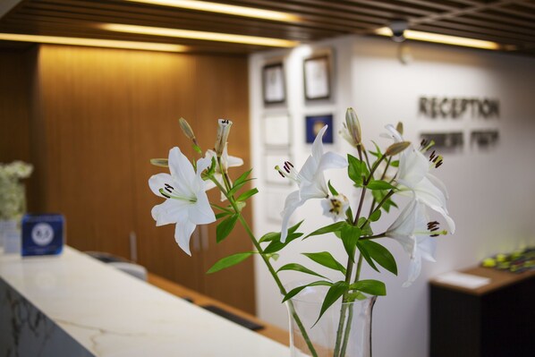 A reception desk with a vase of white flowers. - Hotel Park (Makarska)