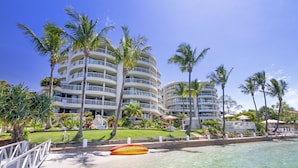 Ein Resort mit mehreren weißen, mehrstöckigen Gebäuden, Palmen und einem Poolbereich.