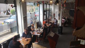 A restaurant with tables and chairs, a piano, and a brick wall. - Orchard Hotel (Falkirk)