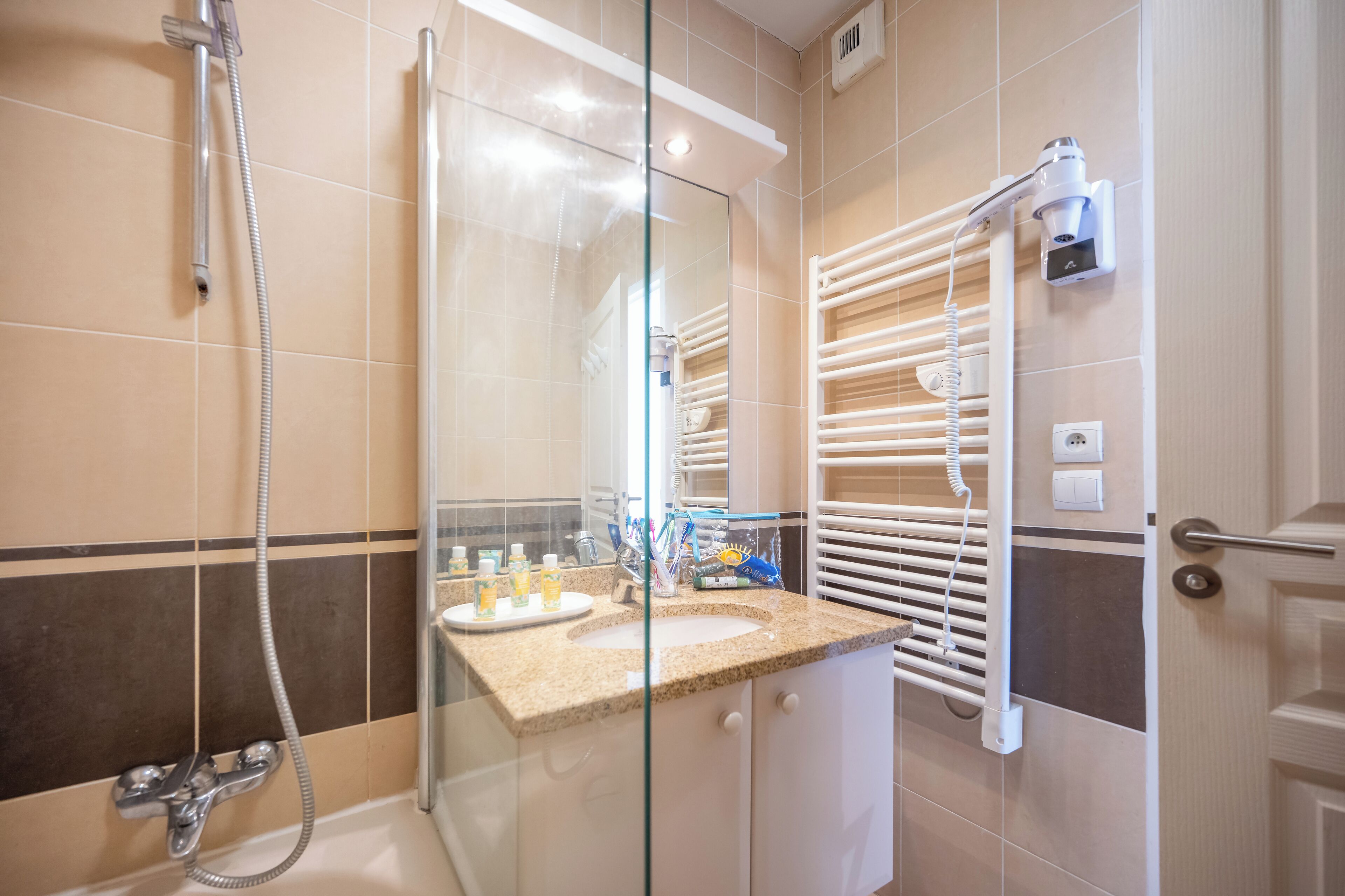 Une salle de bain moderne dotée d’une douche à parois de verre, d’un lavabo intégré et d’un porte-serviettes.