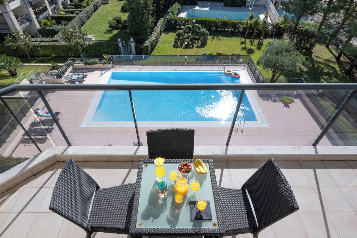 A rooftop terrace with a pool, dining table with breakfast, and outdoor seating.
