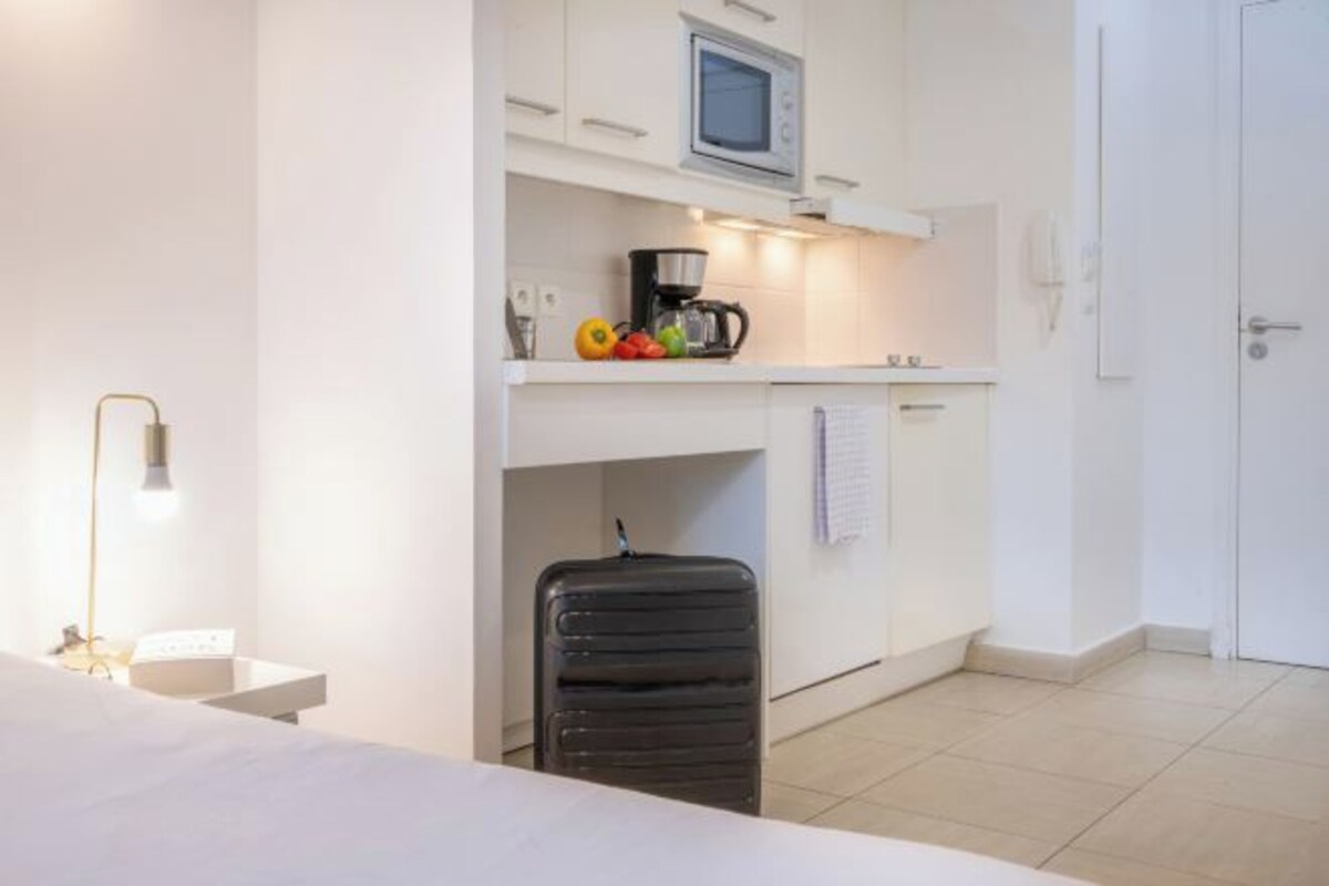 A compact kitchen with a microwave, coffee maker, and a small countertop.