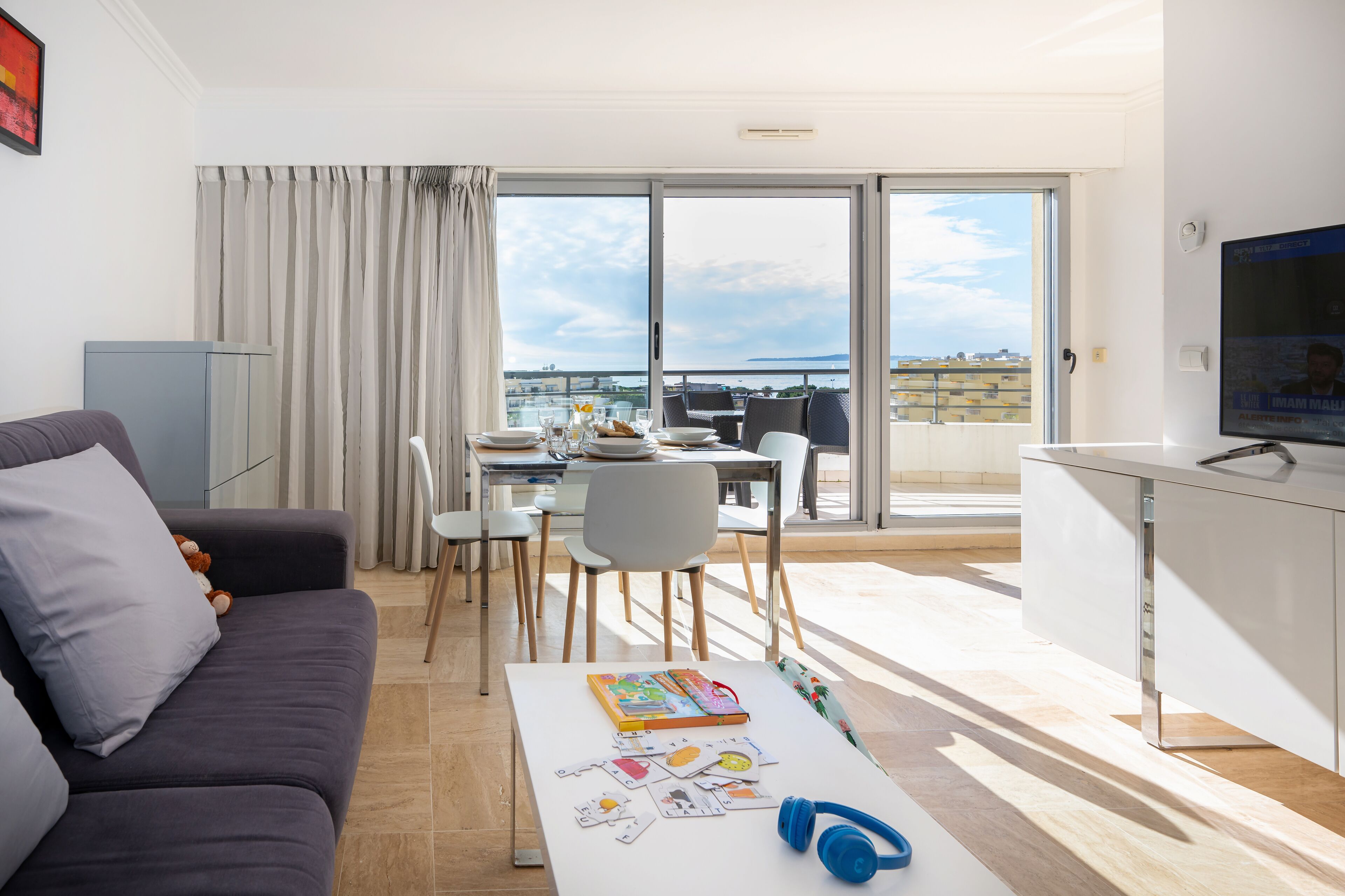 Un salon moderne avec un canapé, une table basse et un coin repas.