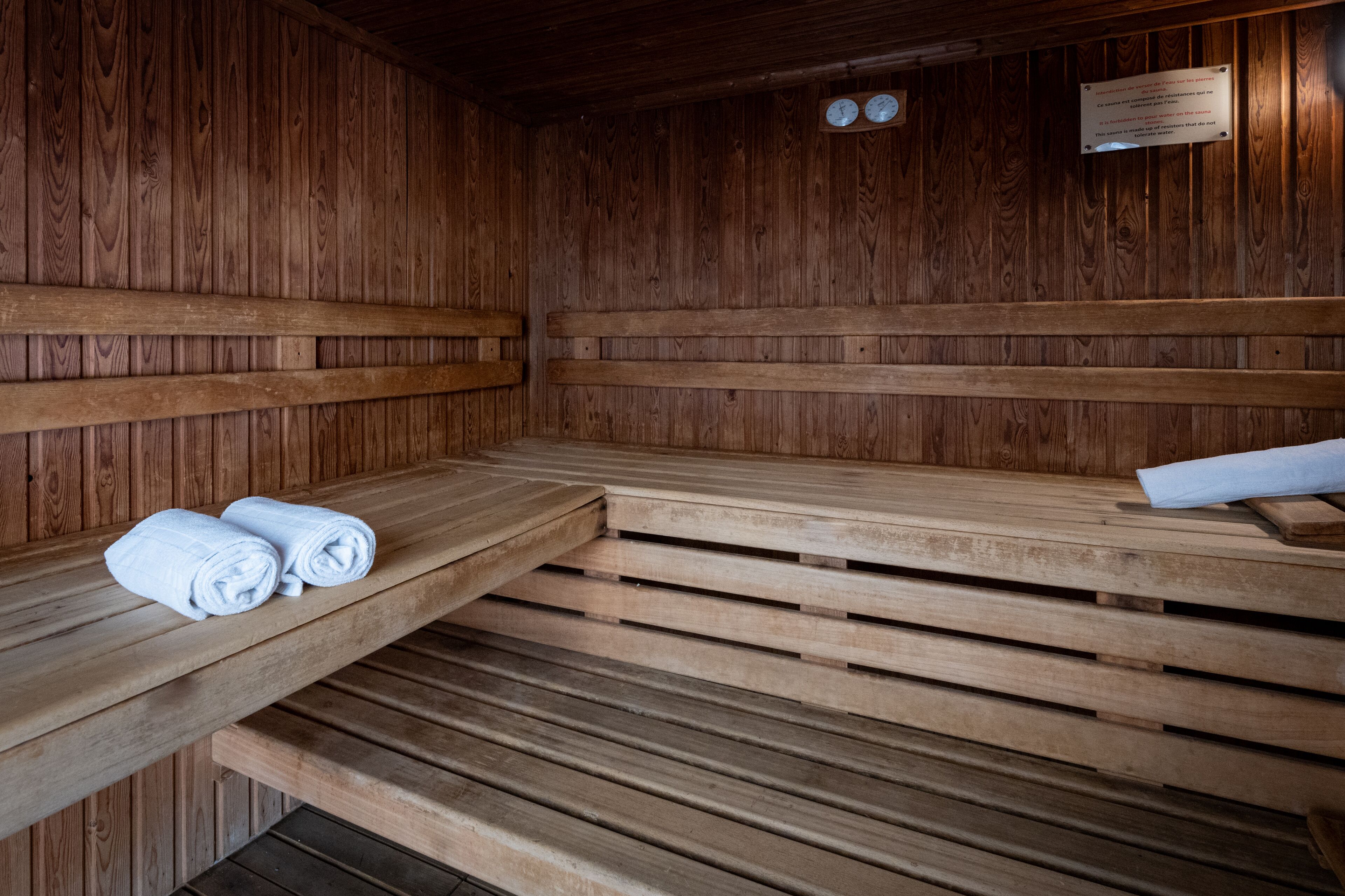 Una sauna de madera con bancos y toallas.