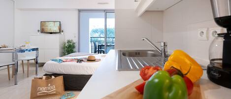 A modern kitchen with a cutting board, knife, and vegetables.