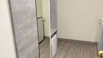 A small, modern bathroom with a grey vanity, a mirror, and a white cabinet.