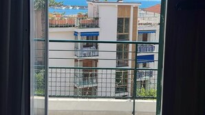 A balcony with a view of a coastal area, featuring a building with balconies and a clear sky. - Hotel Esperia (Sanremo)