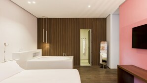 A modern bathroom with a large bathtub, a separate shower area, and a vanity with a mirror. - Palazzo Segreti (Milan)