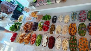 Uma mesa de buffet com diversos alimentos e acompanhamentos.