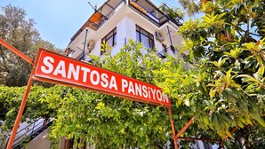 Um edifício com uma placa que diz "SANTOSA PANSIYON" e varandas.