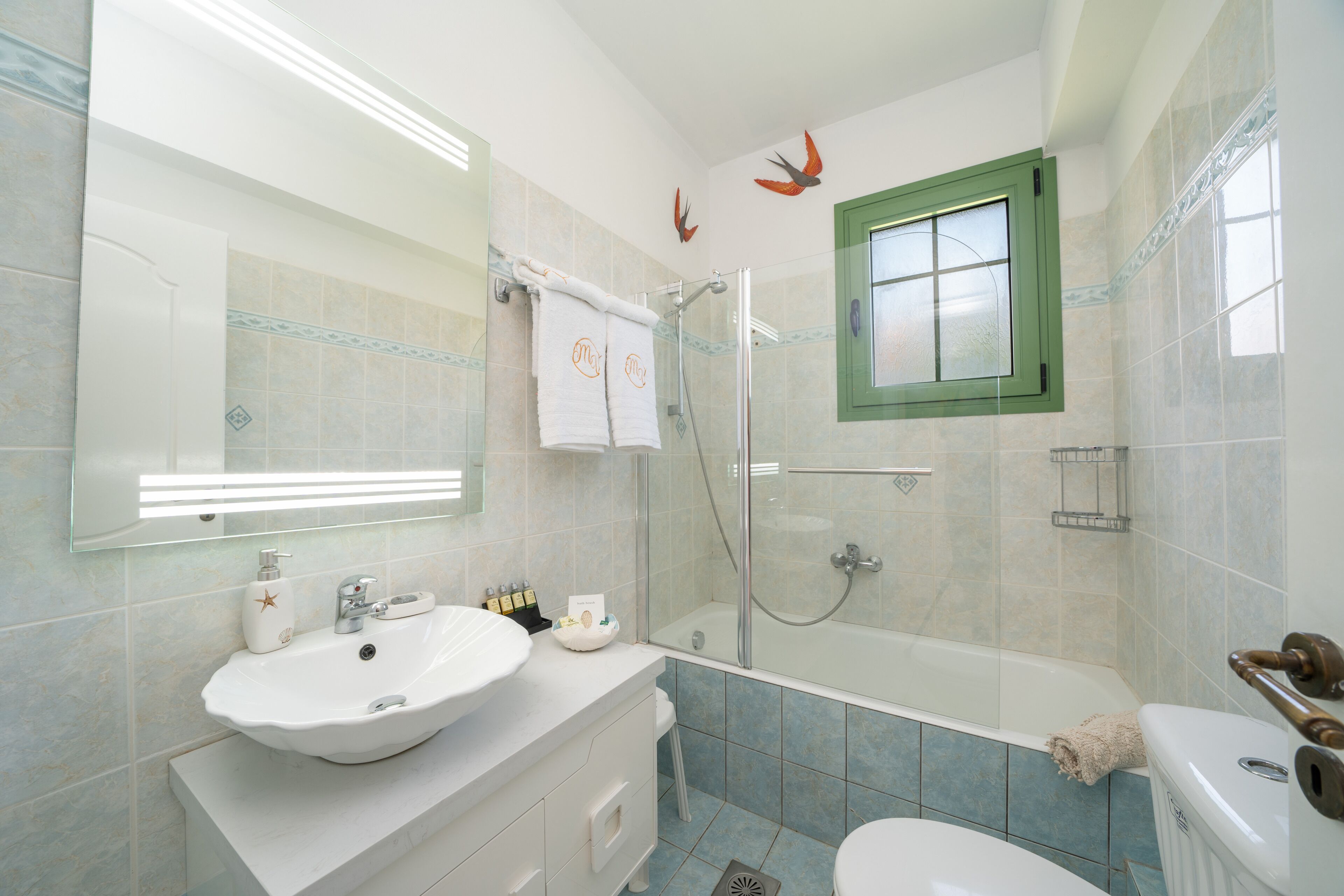 Un baño con lavamanos blanco, cabina de ducha de vidrio y bañera.