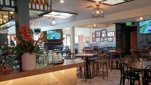 Un restaurante con bolera, mesas y sillas de madera.