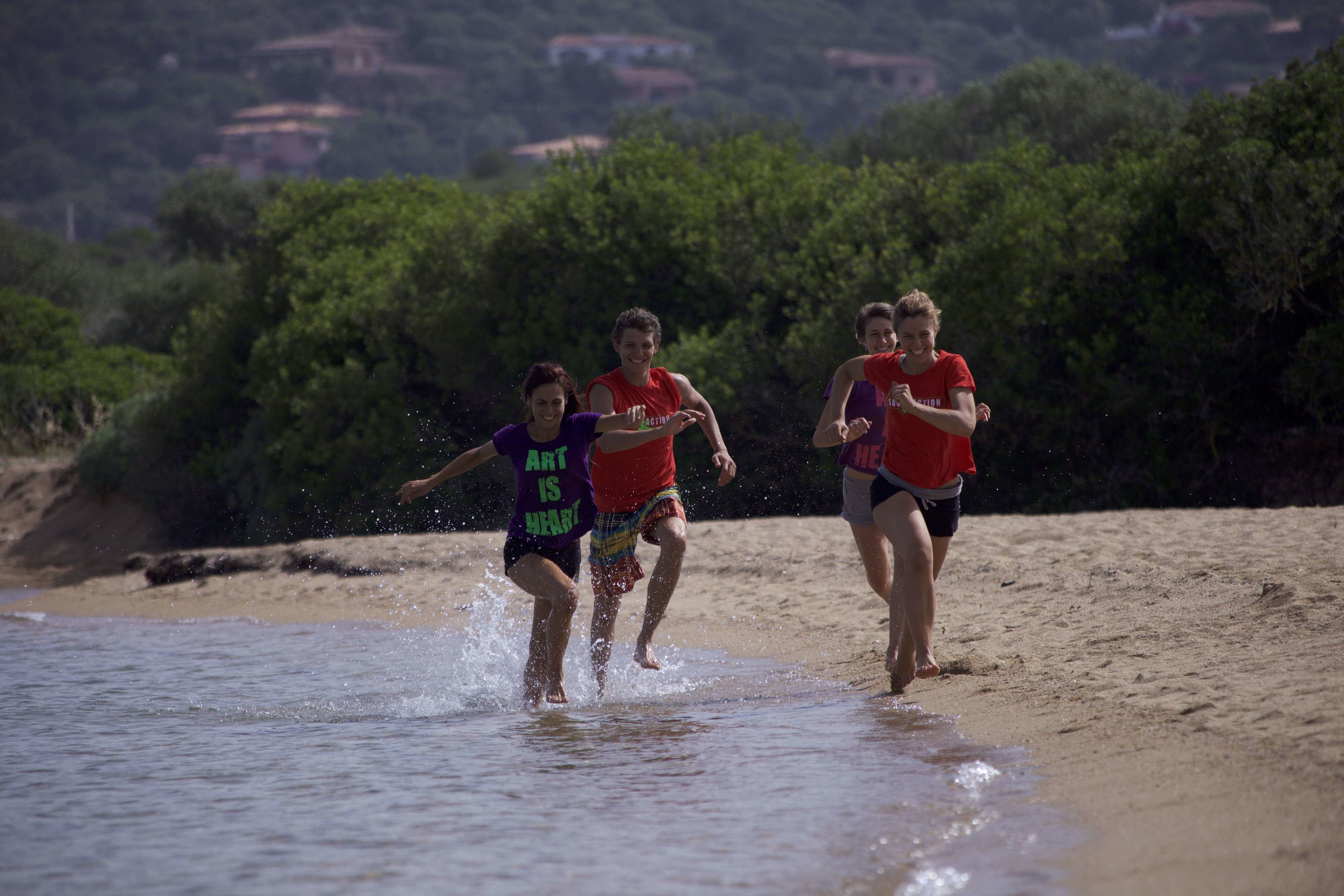 Una spiaggia con persone che corrono in acqua.