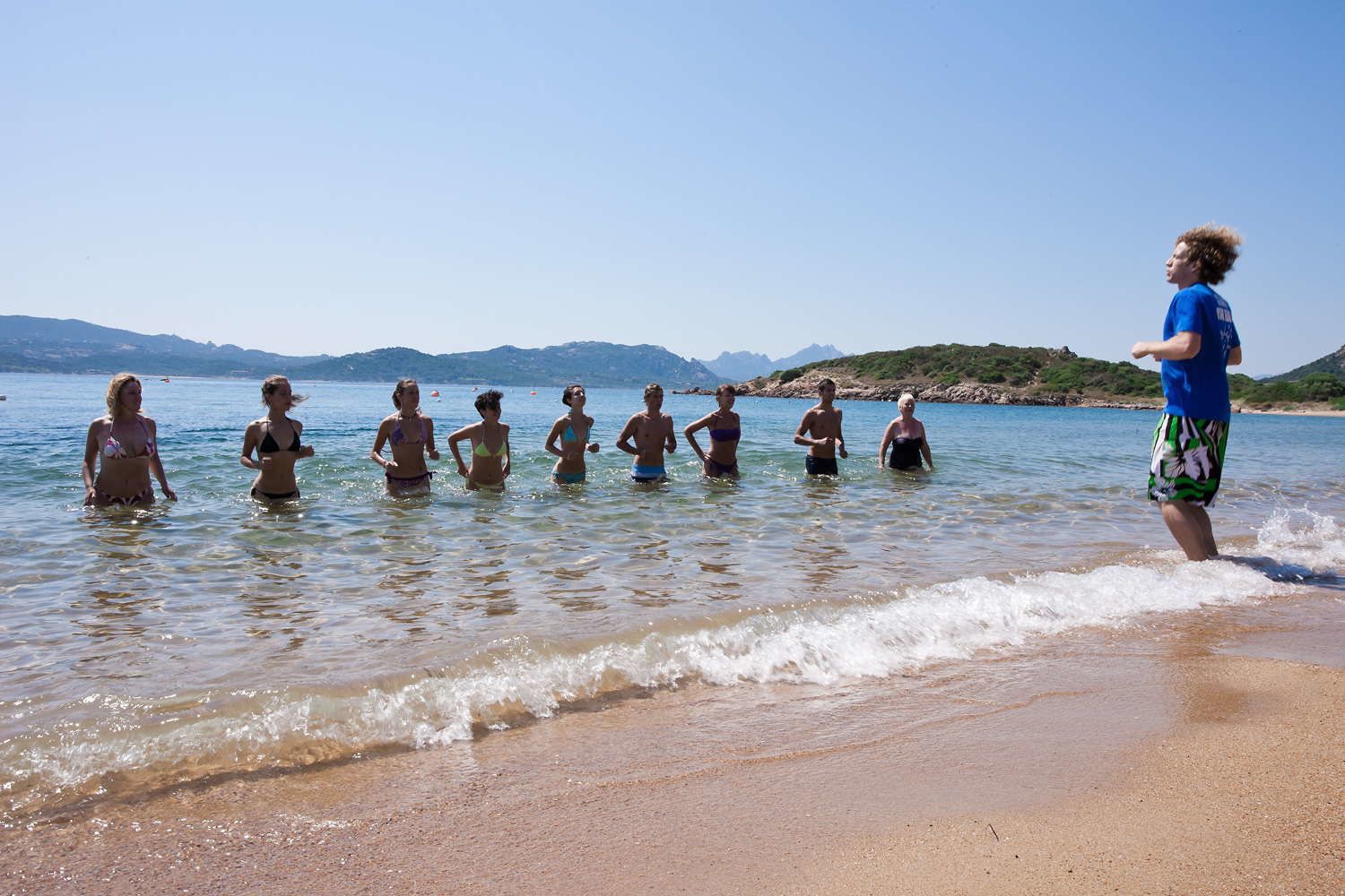 Une plage où des personnes se tiennent dans une eau peu profonde.