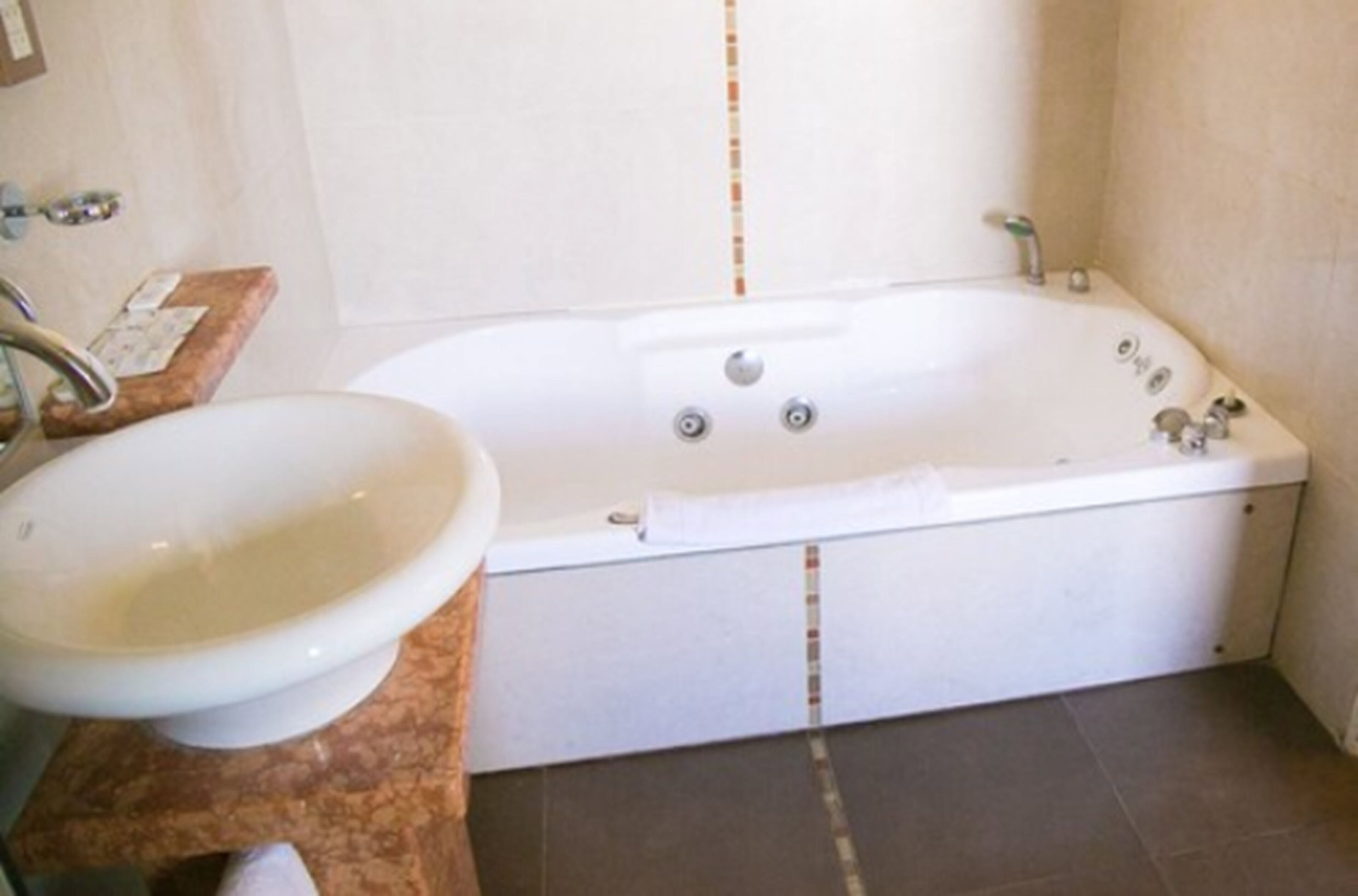 Ein Badezimmer mit einer weißen Badewanne, einem Waschbecken und einer Marmorarbeitsplatte.