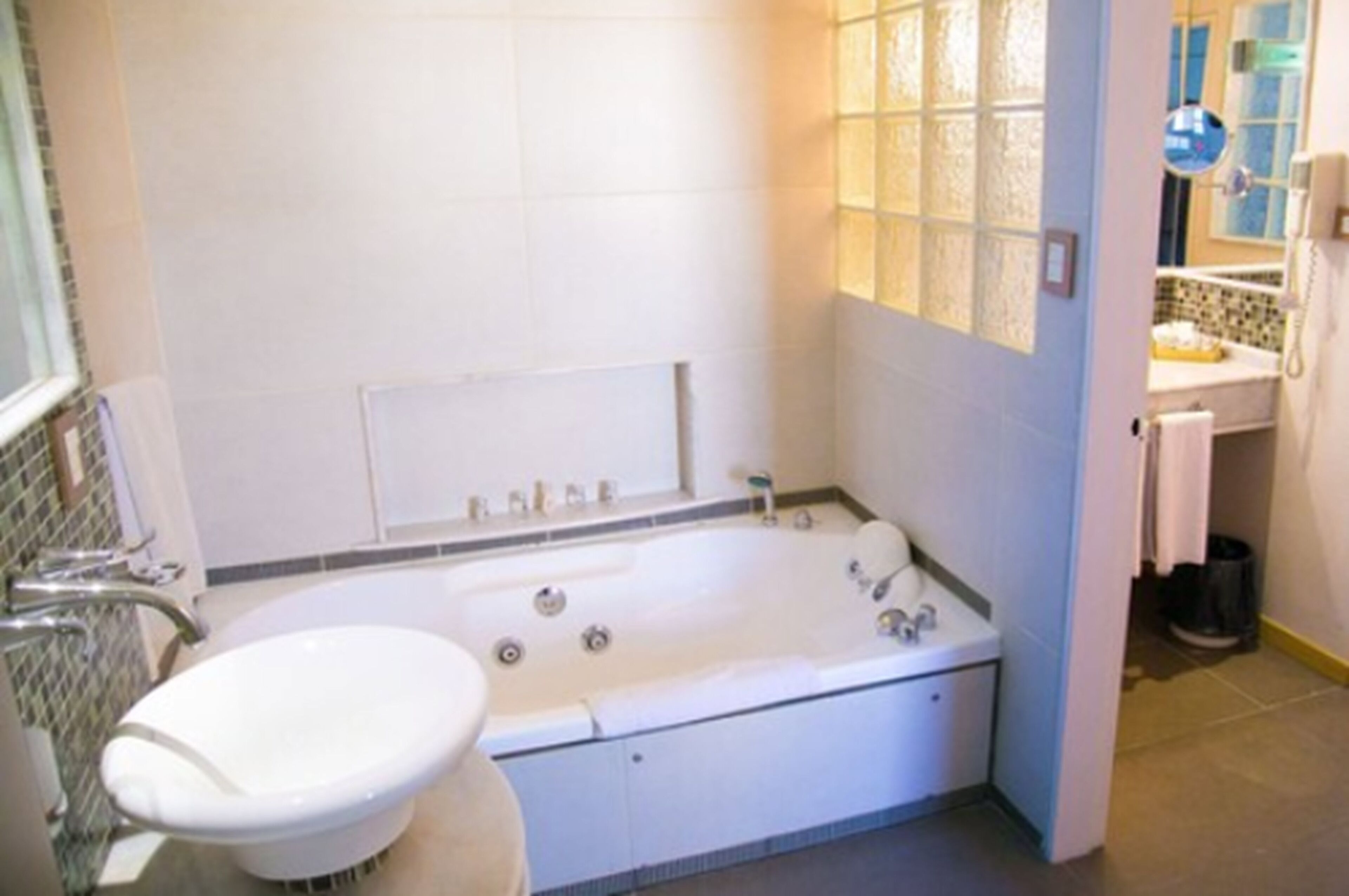 A bathroom with a bathtub, a sink, and a mirror.