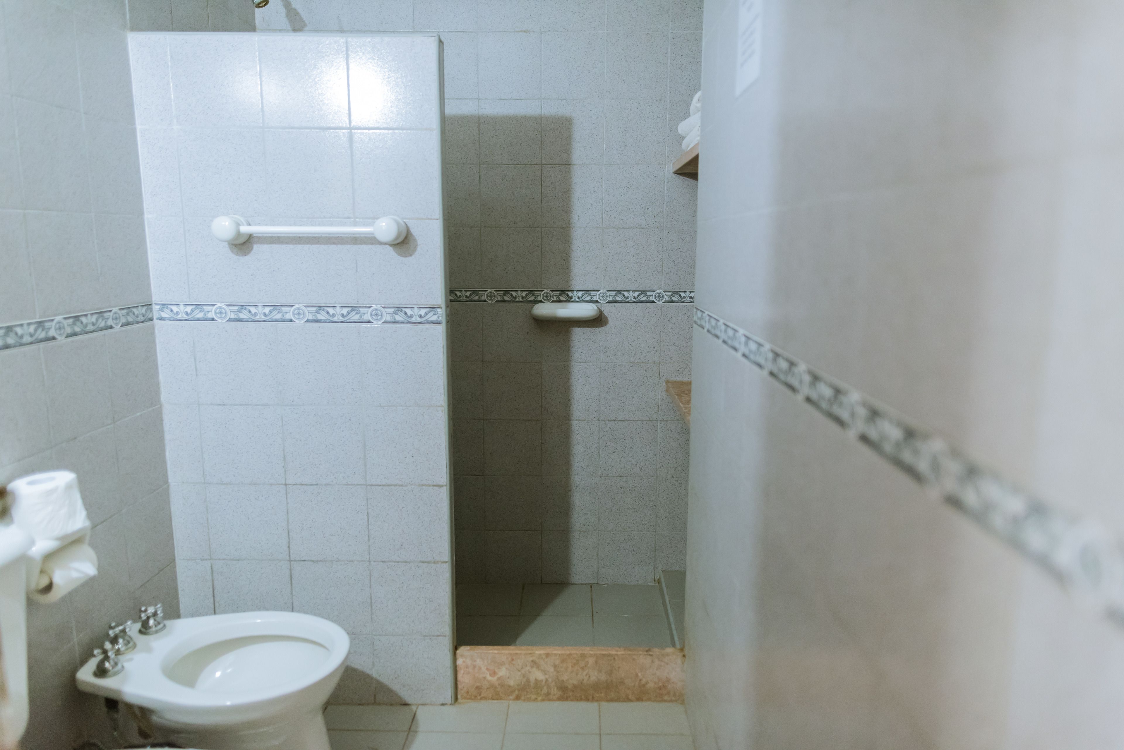 A small bathroom with a toilet, a bidet, and a shower stall.