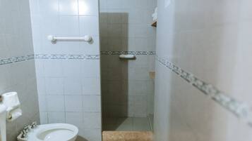 A small bathroom with a toilet, a bidet, and a shower stall.