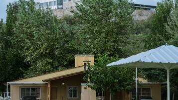 A building with a swimming pool, surrounded by trees.