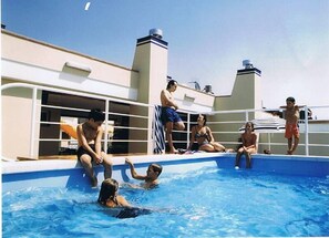 Una piscina al aire libre de temporada, sillones reclinables de piscina