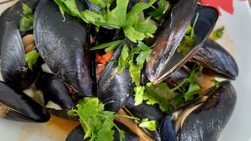 A plate of mussels garnished with parsley.