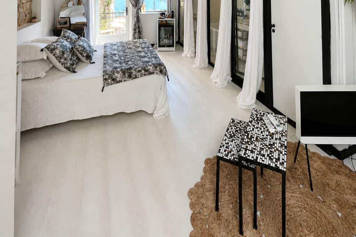 Een slaapkamer met een bed, een bureau, een televisie en uitzicht op de omgeving.