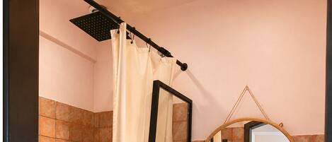 A bathroom with a bathtub, a sink, a mirror, and a shower curtain.