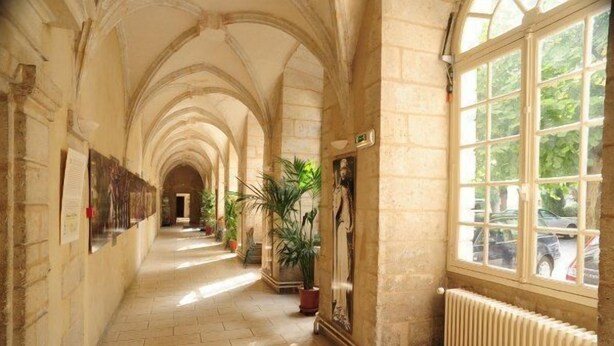 A corridor with arched ceilings, potted plants, and a radiator. - Hotellerie Saint Yves (Chartres)