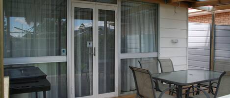 A patio with a glass door, a table, and chairs.