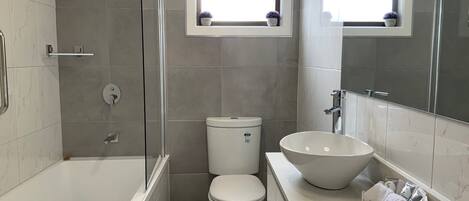 Un baño moderno con bañera, inodoro y lavamanos.
