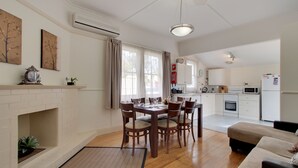 A modern kitchen with white cabinets, a microwave, and a built-in oven. - Moonah Central Apartments (Moonah)