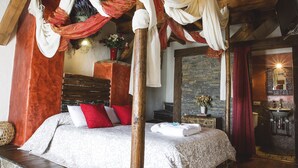 A four-poster bed with draped fabric, a stone base, and a wooden ceiling. - Casa Rural Therma Agreste (Bermellar)