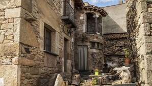 A narrow stone building with a wooden staircase leading to a door. - Casa Rural Therma Agreste (Bermellar)