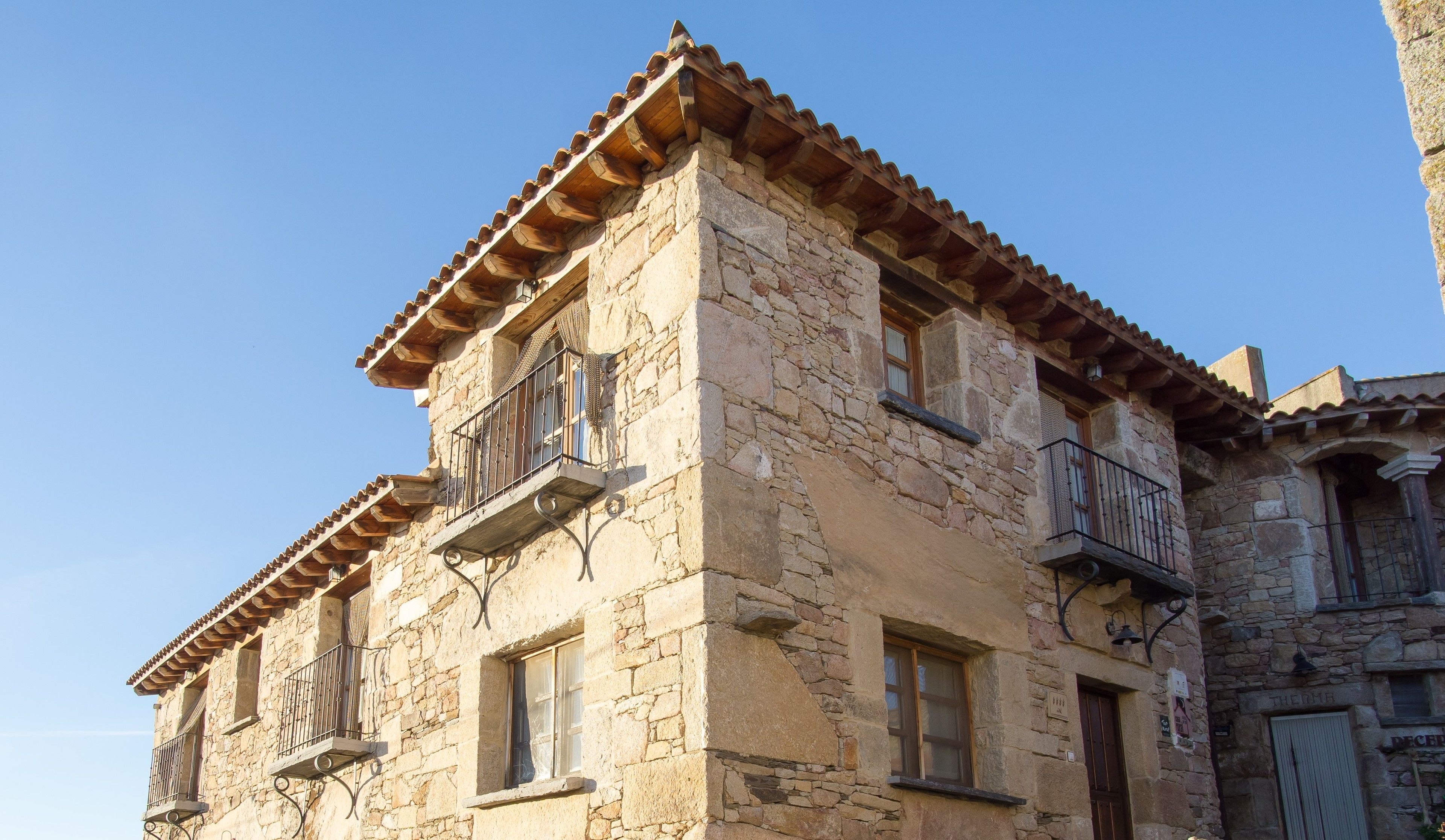 Un edificio de piedra con varios balcones y techo de tejas.