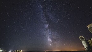 A night sky with stars and the Milky Way visible above a balcony with potted plants. - Casa Rural Therma Agreste (Bermellar)