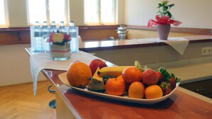 Un plan de travail de cuisine sur lequel se trouve un panier de fruits contenant des oranges, des bananes et des fraises.