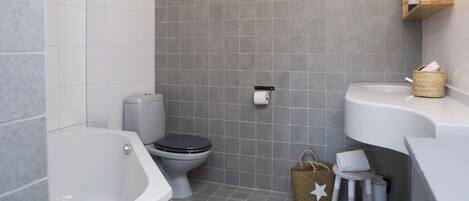Un baño moderno con bañera, inodoro y lavabo.