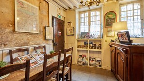 Una posada tradicional con muebles de madera, un mapa en la pared y diversos objetos en estantes.