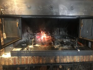 En öppen ugn med synliga lågor och ett metallgaller.