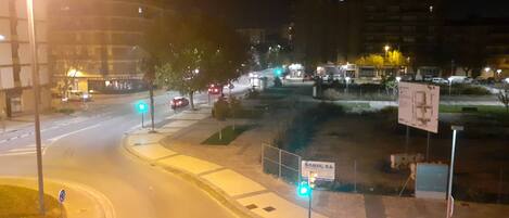 A nighttime street scene with traffic lights, a pedestrian crossing, and a sign for Domicile S.L.
