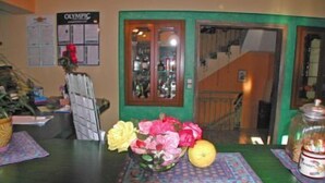 A reception desk with a vase of flowers, a lemon, and a glass jar. - Harmony Resort (Parga)