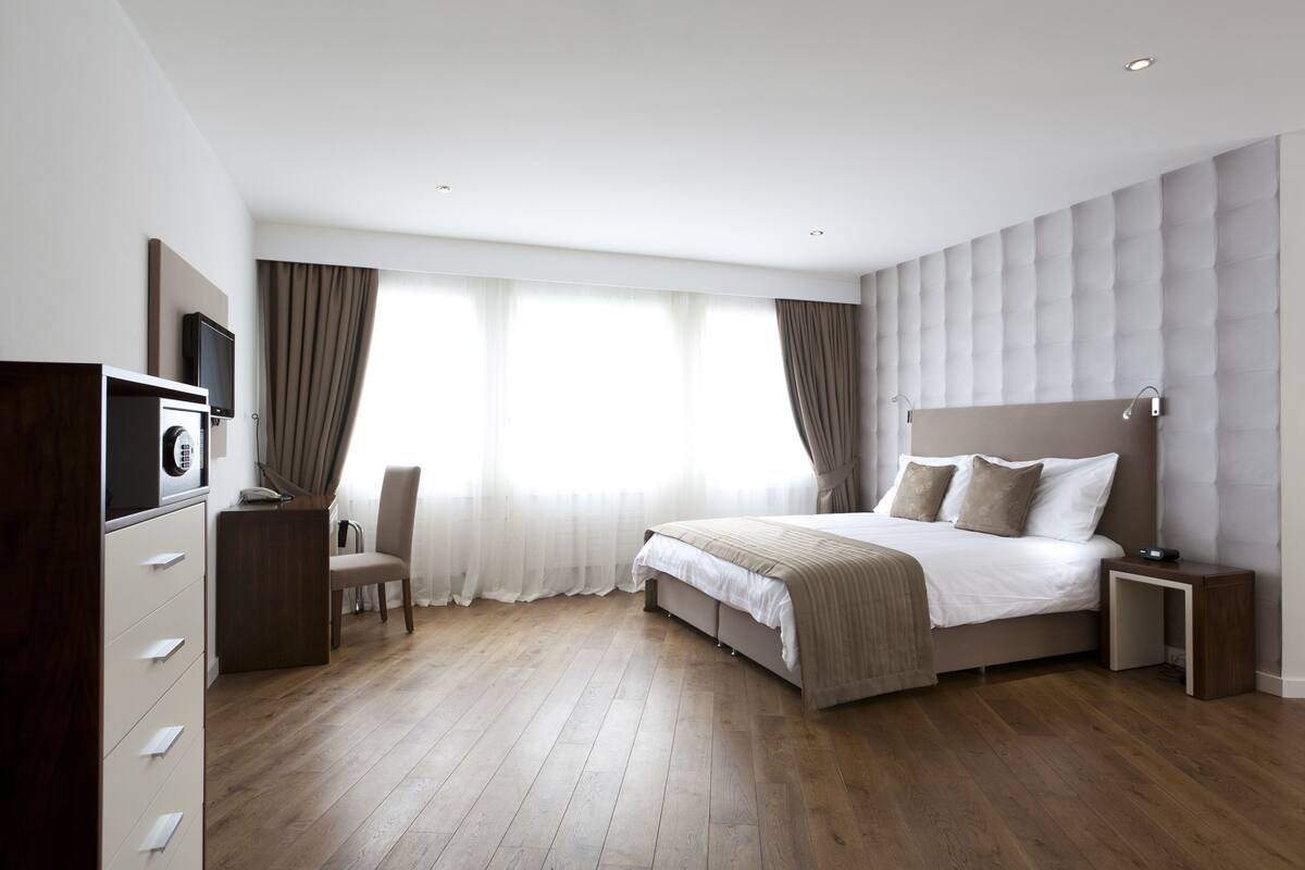 Um quarto moderno com uma cama grande, uma escrivaninha e uma cadeira.